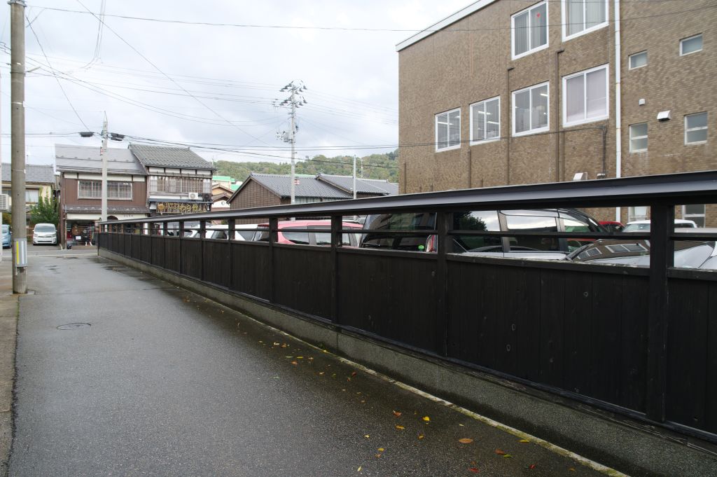 安善小路・駐車場を隔てる黒塀