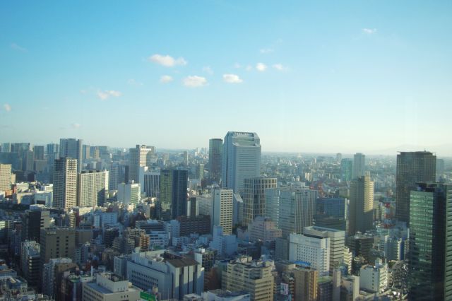 南西方面、田町駅方向。都会風景が遠くまで続く。ＮＥＣ本社ビルが目立つ。遠くには山並みも見える。