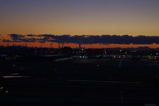 正面は横浜ランドマークタワー。工場群の煙突と共に夕空に突き出しています。