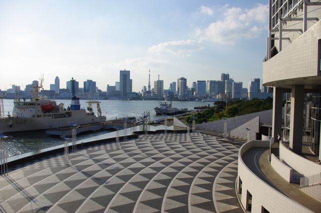 開放的なターミナル広場と陸側のビルの並ぶ都市風景。