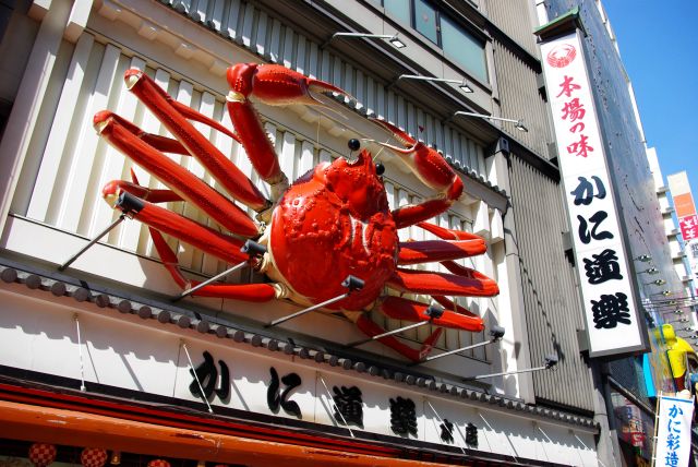 大きなかに道楽の看板が動く。店前で売られている蟹の良い香りが漂う。