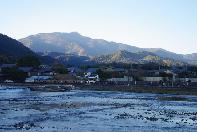 渡月橋背後には紅葉の山並み。