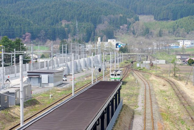 西側から1両の在来線がやって来ます。新幹線の線路は途切れ、奥には工事中のトンネル。