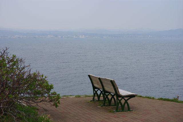 東側のベンチへ。湾の向こうの函館東部の街並みや山並み。