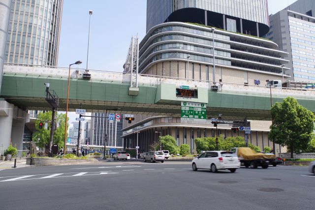 地下鉄肥後橋駅から上がると車通りの多いビル群の街並み。