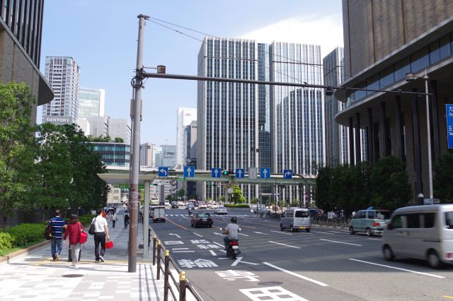 高層ビルの間の四つ橋筋は車通りが多い。