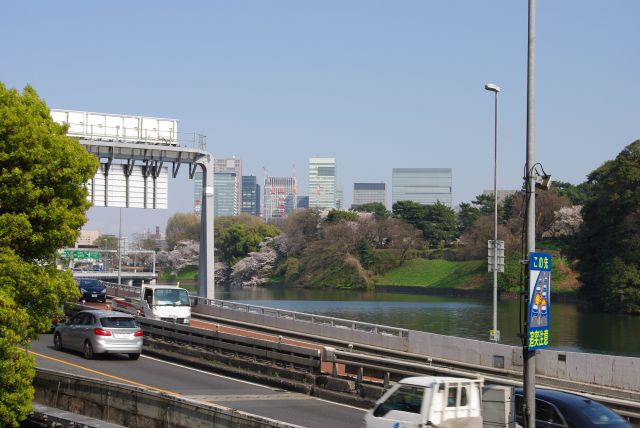 濠沿いに首都高都心環状線。皇居の向こうに丸の内のビル群。