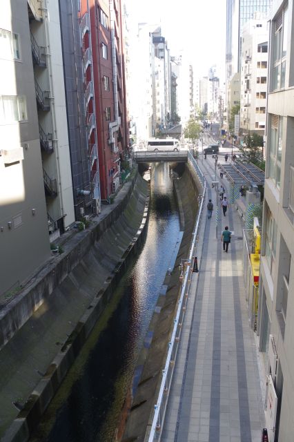 渋谷川は続き、人々も行き交います。