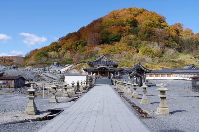 山門をくぐると奥には地蔵殿。背後には紅葉の山。