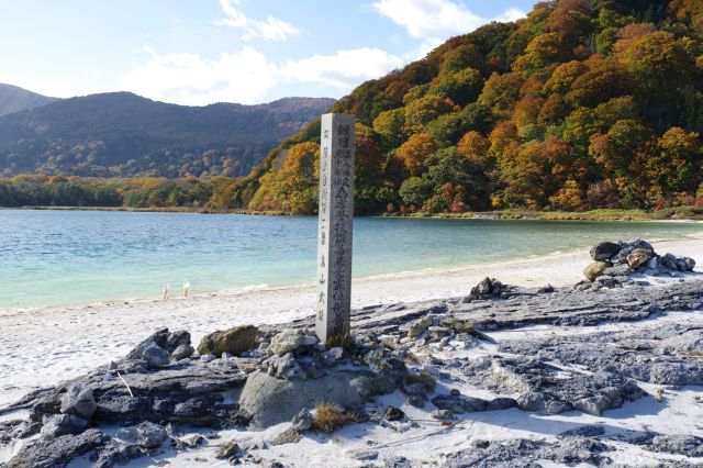 湖畔に立つ供養塔。