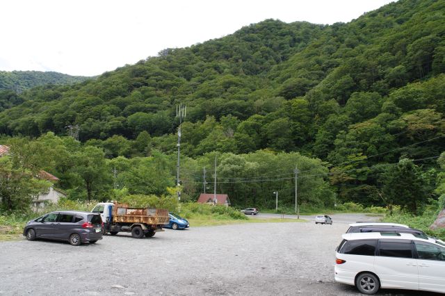 駅舎を出ると外は自然の中。砂利道に車が止まる。