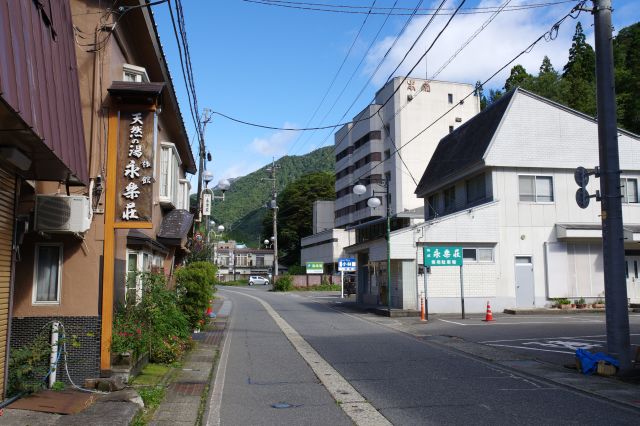 旅館が立ち並ぶ静かな街並み。ひと気はなく、車はたまに通る。