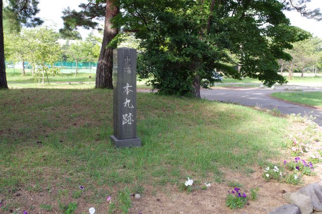 本丸跡の石碑。奥には中学校。