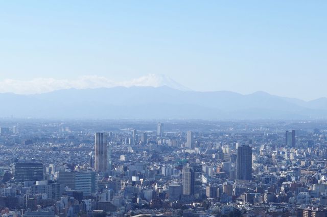 山並みにうっすらと顔を出す富士山。