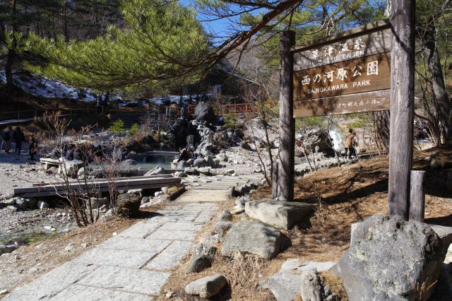 公園の看板。奥には足湯があります。