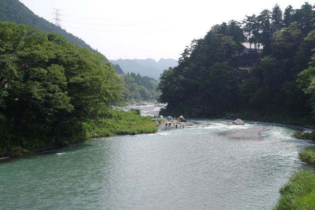 緑豊かな渓谷を曲がりながら流れる川。