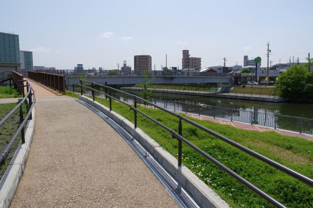 運河を渡る歩道のスロープを登ります。左奥には公衆トイレ。