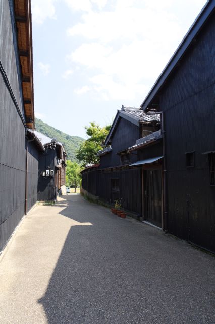 黒い壁の建物に囲まれた路地裏。