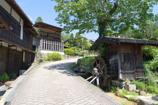 カーブする坂道に水車小屋があります。