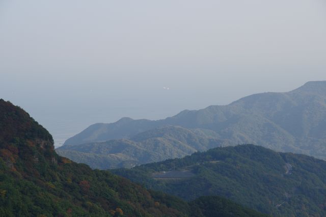 左奥の山並の向こうの海と船。