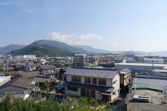 東側の眺望。ひしめく建物と山並の風景。