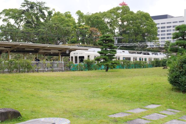 石垣や堀に面した駅、電車が停まっています。