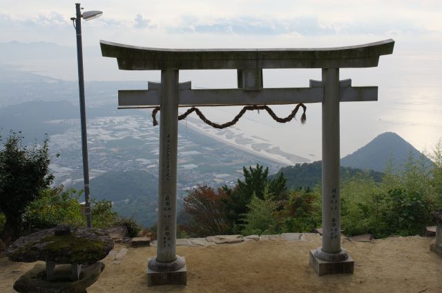 鳥居越しにみる街、スケールのギャップにこれだけの高さを登ってきたんだと実感できます。