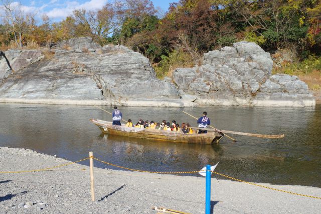 船下りが船が行き交います。対岸には削ったような岩肌。