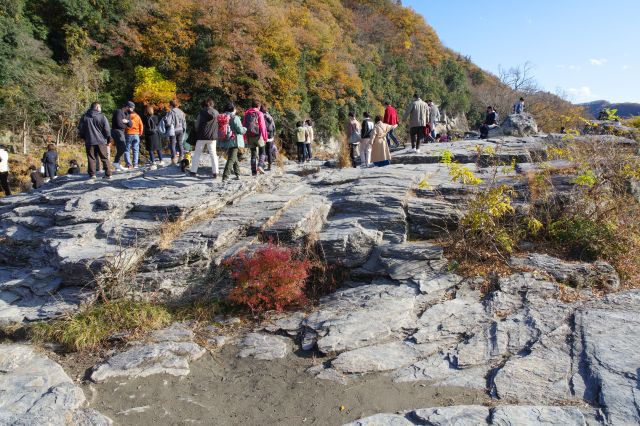 沢山の人と筋の入った岩場。