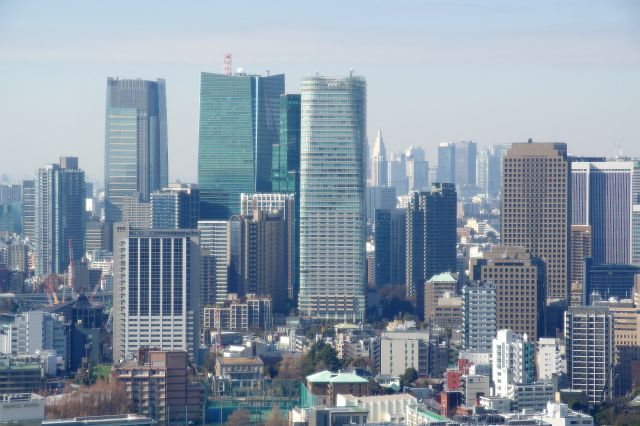 六本木一丁目駅周辺のビル群。右奥には新宿の超高層ビル群。