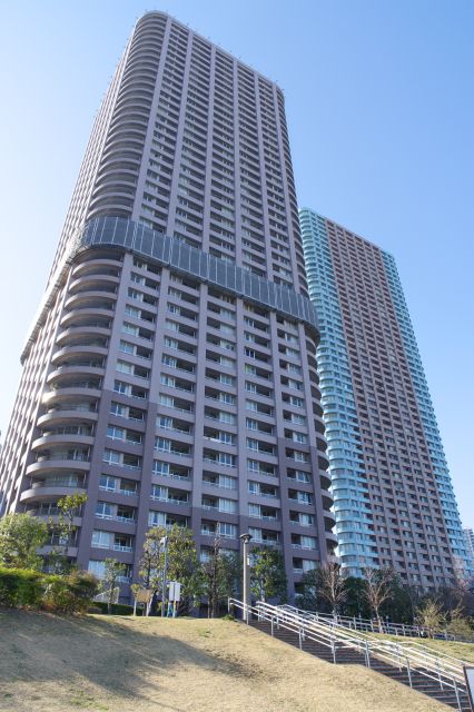 終始背後にそびえ立つ高層マンション群。