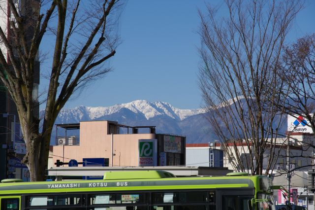 奥には冠雪した山並が見えます。