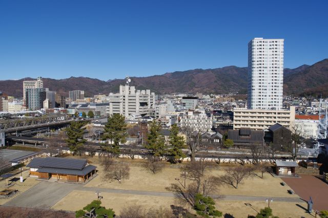 北側は稲荷曲輪と、中央線と身延線の線路の先に町並み。