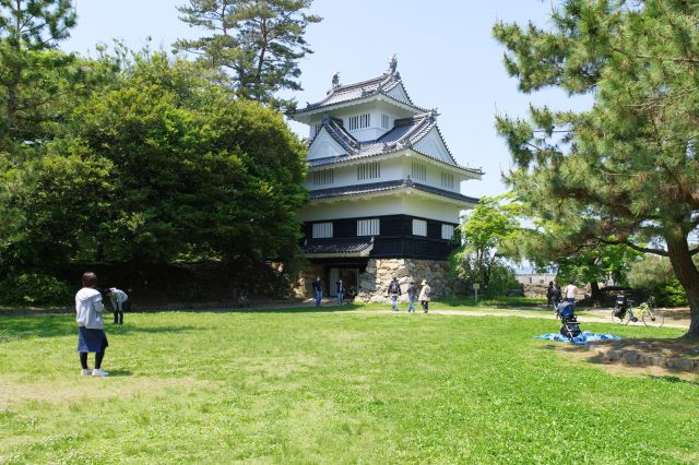 北西側には再建された鉄櫓（くろがねやぐら）があります。周辺には憩う人達。