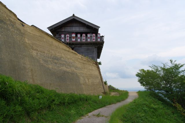 左は高い土塁、右も斜面の狭い道を進み西門へ。