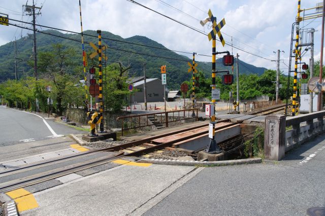 伯備線の静かな踏切。川の両側に道路があります。