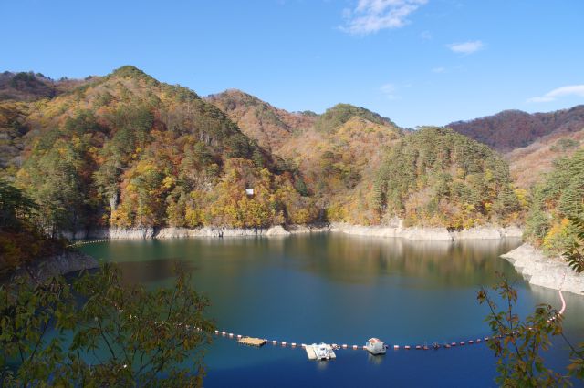 ダム湖が見えてきました。周囲の山は紅葉しています。