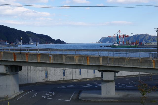 横切る道路の先の海。震災の津波の悲劇、今は静かな海と防潮堤が巡る海沿い。