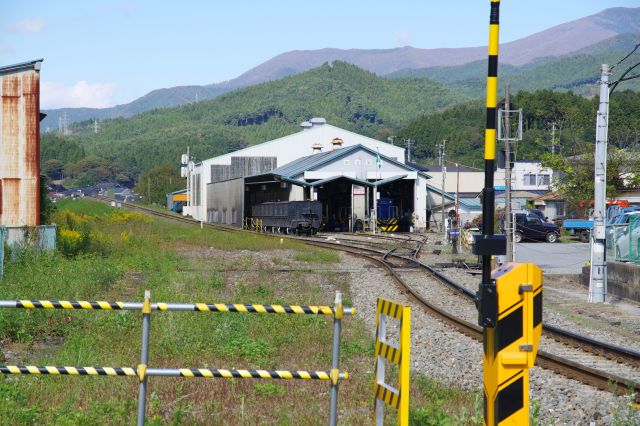 北側は内陸へと勾配を登る線路、脇に車庫があります。