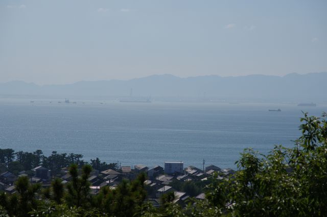 山並と工場らしい煙突。