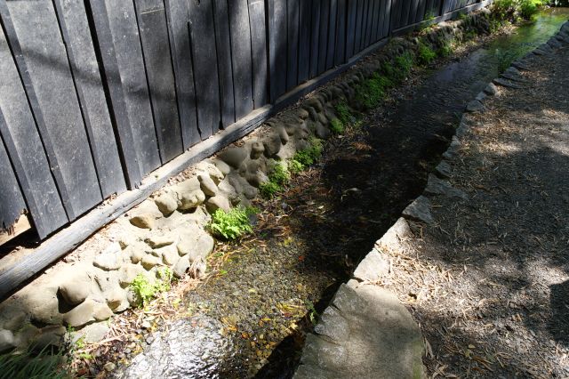 清らかな流れと黒い塀。