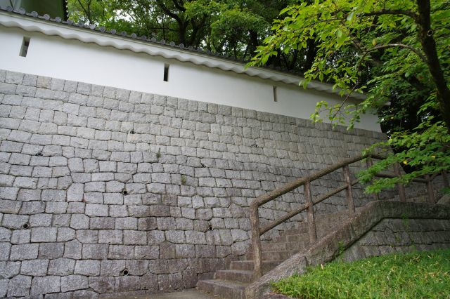 横に伸びる石垣と塀の壁、階段があります。