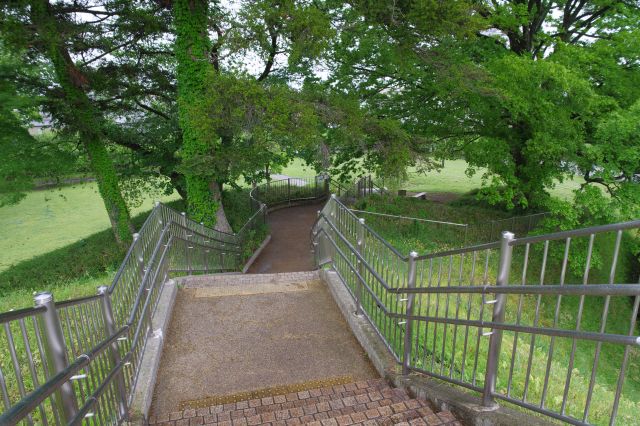 土塁の端から階段を下ると緑の木々へ。
