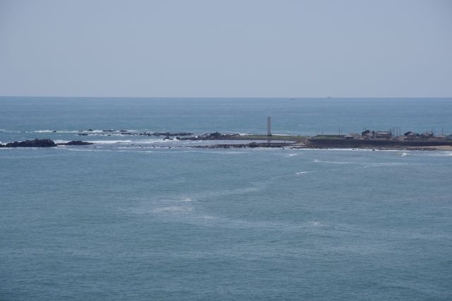 先端部の長崎鼻一ノ島照射灯と岩礁、伸びる水平線。