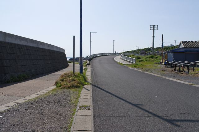 堤防は左の岩場へ、道の右への坂。