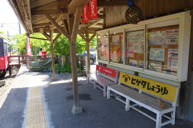 木造の柱と屋根、ベンチや掲示板など。