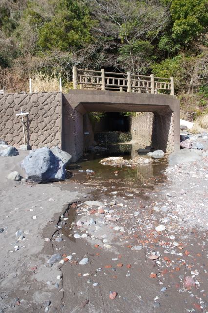 後ろには水が流れ込む川。