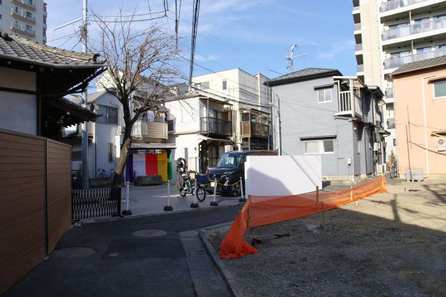後方、住宅が密集する静かな狭い路地です。